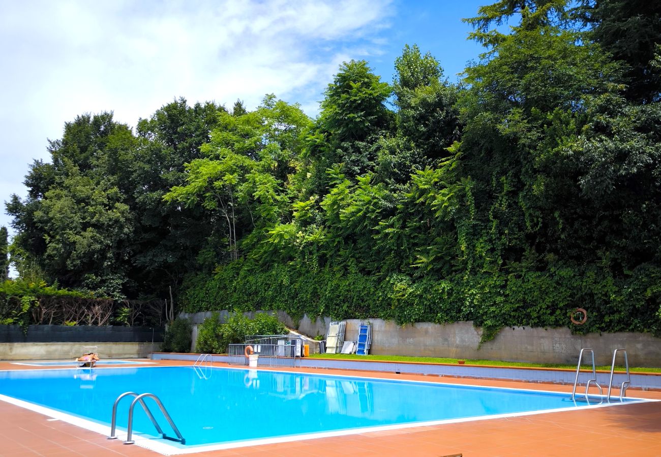 Piscina all’aperto con bordo in cotto e prato verde in residence a Colà