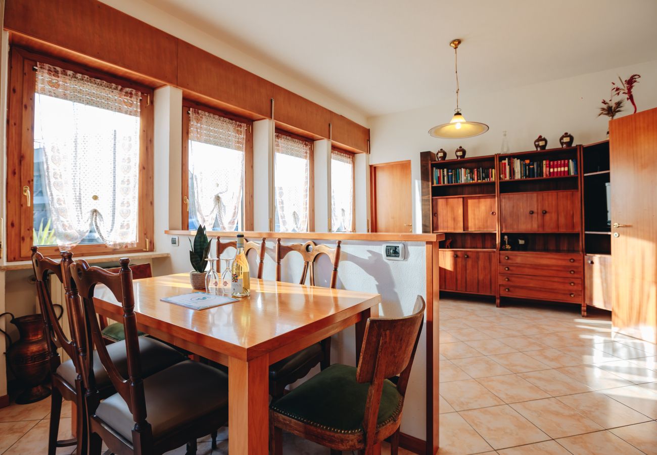 Dining room with wooden table and large windows in the flat in Peschiera del Garda