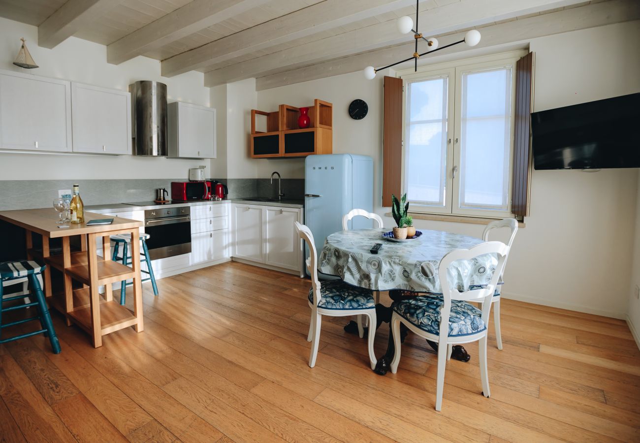 Cuisine équipée avec table à manger et réfrigérateur vintage dans un appartement à Peschiera del Garda