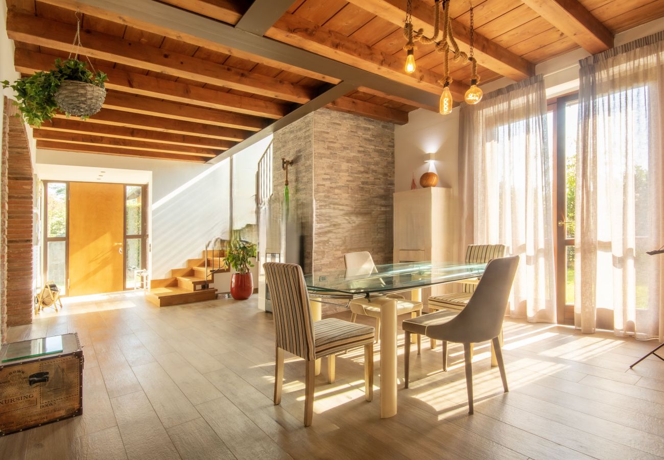 Séjour avec table en verre et poutres apparentes dans une villa à Lazise