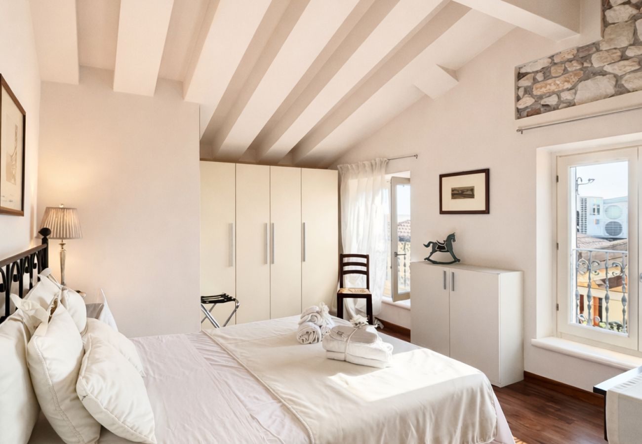 Chambre double mansardée avec poutres apparentes dans un appartement situé dans le centre de Lazise